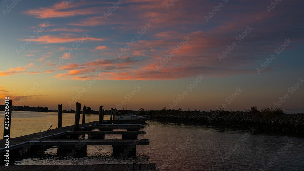Φωτογραφία A tranquil scene captures a dock extending into the calm waters at sunset