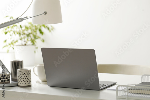 Fényképezés Stylish workplace with laptop, stationery, candles, cup and lamp indoors