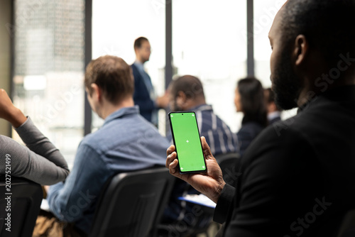 Photos Vertical chroma key phone held by black participant at international summit with guest speaker
