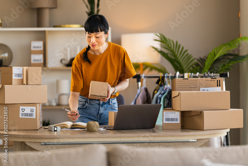 Woman packing online orders at home office for small e-commerce business