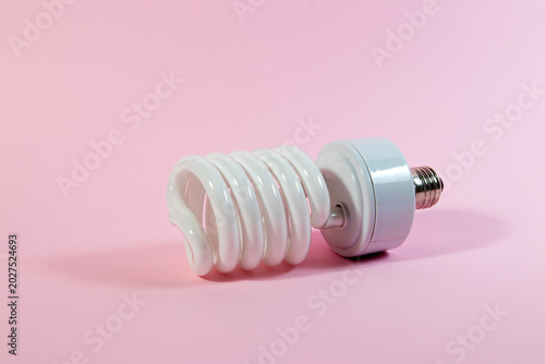 Fotografie An energy saving fluorescent light bulb on a pink background