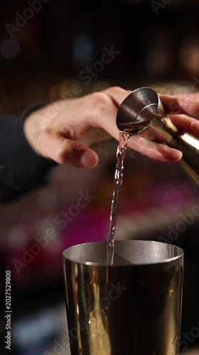 A skilled bartender expertly crafts a fresh cocktail behind a stylish bar counter