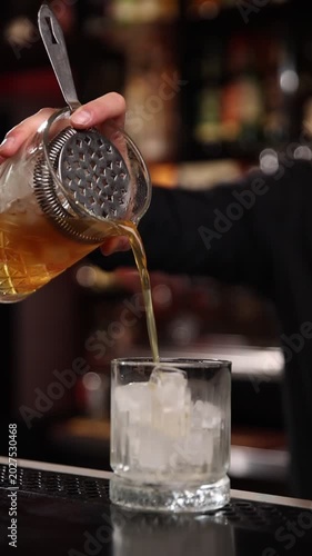 A skilled bartender expertly crafts a fresh cocktail behind a stylish bar counter
