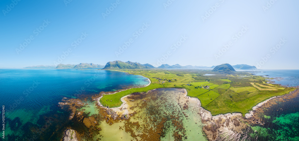 Fototapeta premium Drone view of the Arctic Ocean coastline, Lofoten Islands, Norway. A panoramic view of the northern summer. Scenic arctic landscape with beach, ocean and northern nature. Background and wallpaper.