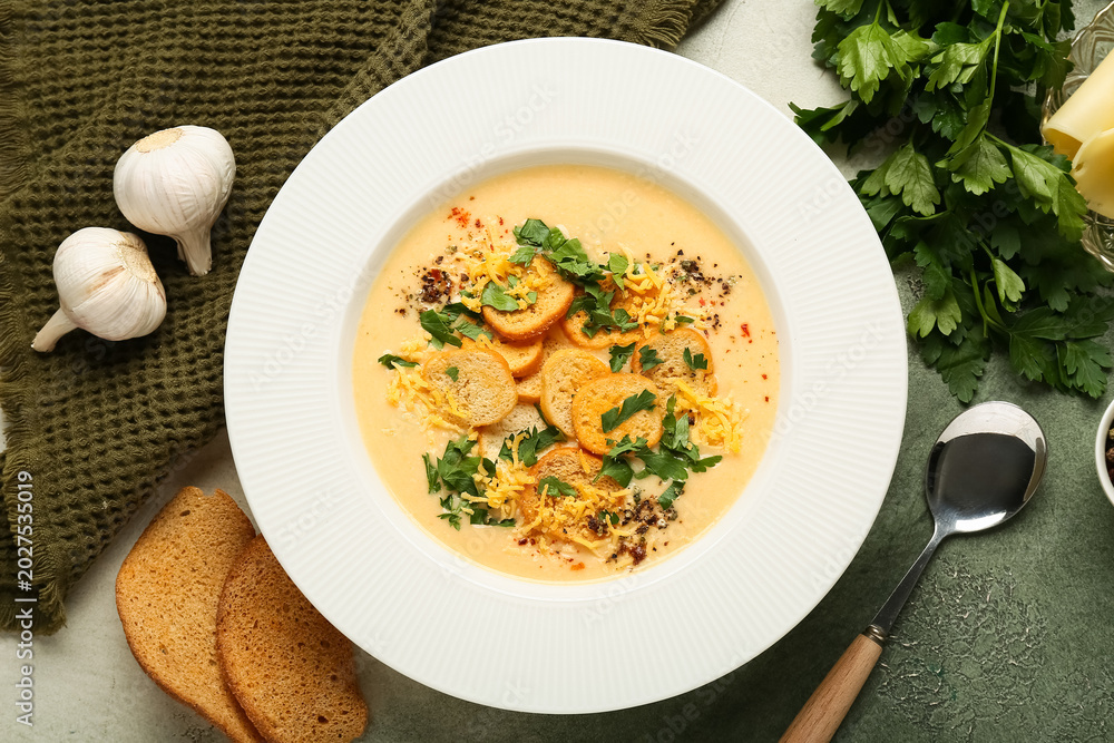 Obraz premium Bowl of tasty cheese soup with parsley and croutons on grunge background