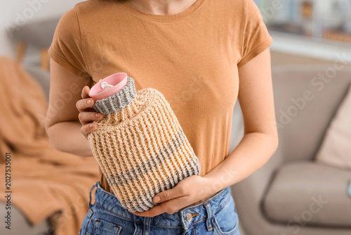 Valokuva Young woman with hot water bottle at home, closeup