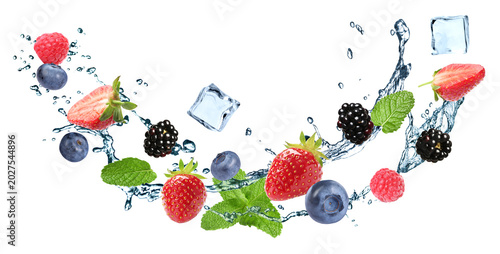 Fresh berries, ice cubes, mint and splashing water in air on white background