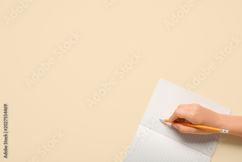 Female hand writing in note...
