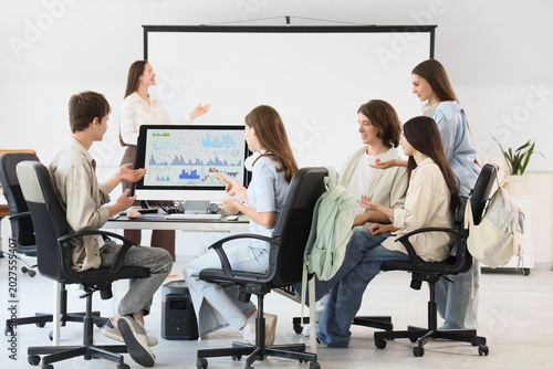 Teenage students with teacher studying at school computer lab