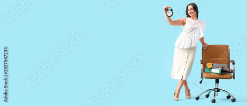 Businesswoman with alarm clock near chair on blue background. Time management...
