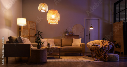 Obraz na plátně Interior of stylish living room with cozy grey sofas, coffee table and glowing l