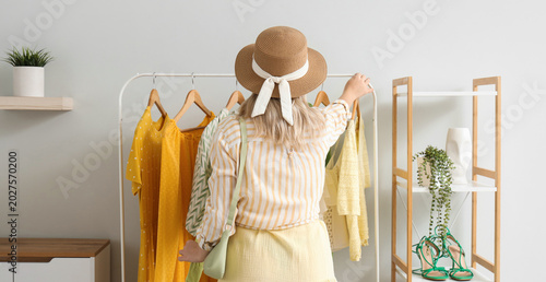 Young woman near clothes ra...