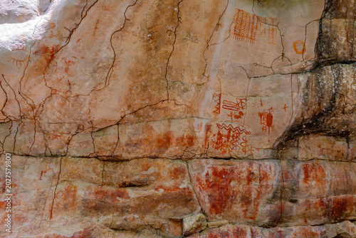 Slika na platnu Ancient pictographs on rock surface showcasing vibrant red and orange hues