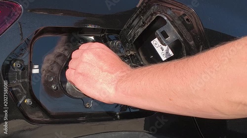 Close up of hand opening car fuel cap and unscrewing tank cover, preparing for refueling, vehicle exterior detail, gas station concept, automotive maintenance and operation