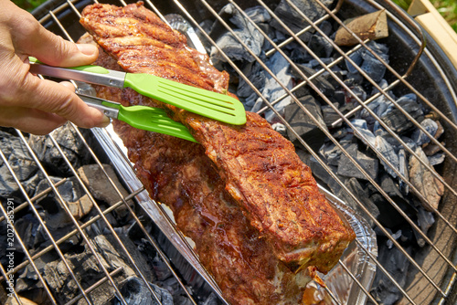Pork ribs grilling. Outdoor cookout featuring grilled pork ribs with golden crust and smoky flavor in summer