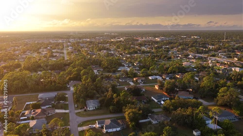Overhead view of small town neighborhood in evening with single family houses, driveways and trees. Calm suburban living, property ownership and American dream lifestyle concept.
