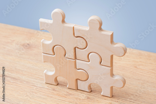 Tableau sur toile Wooden puzzle pieces connected on blue background with copy space