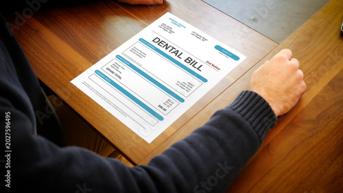 Fotografija A Stressed Out Man Looks at a Dental Bill or Dental Claim