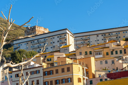 View of residential housing on the slopes of The Rock of Gibraltar, featuring the historic, medieval Moorish Castle at the top, in Gibraltar.