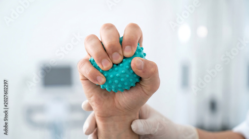Squeezing a spiky massage ball for hand therapy