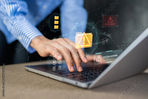 Businessman typing on laptop with system warning and hacked file data folder alert
