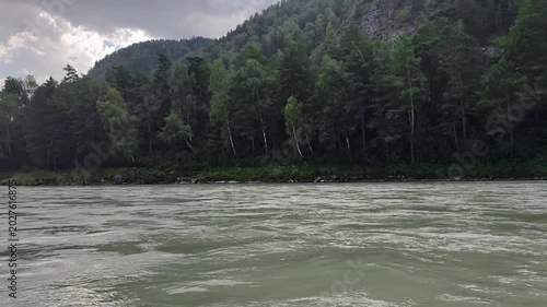 A motorboat ride along mountain river. Slow motion of speedboating on Altai river Katun in rainy day
