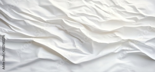 crumpled white bed sheet with soft folds and gentle shadows evoking calm and cozy minimalism