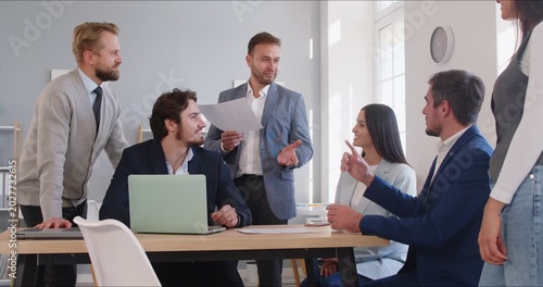 Business team meeting with manager leading presentation. Colleagues review notes during discussion, briefing and training together. Concept collaboration, strategy, and leadership communication.