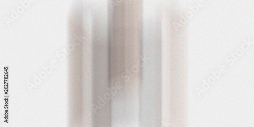 Abstract vertical streaks of light grey and beige in soft blurred motion with grainy texture on a white background creating subtle elegant design.