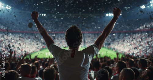 Fan celebrating victory in stadium with confetti raining