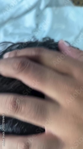 south east Asian man checking hair loss and receding hairline with phone camera