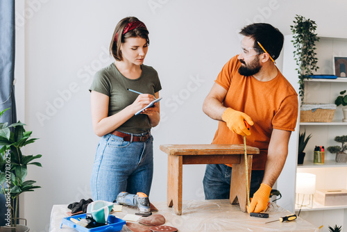 Bild auf Leinwand Happy couple working on home renovation furniture restoration project