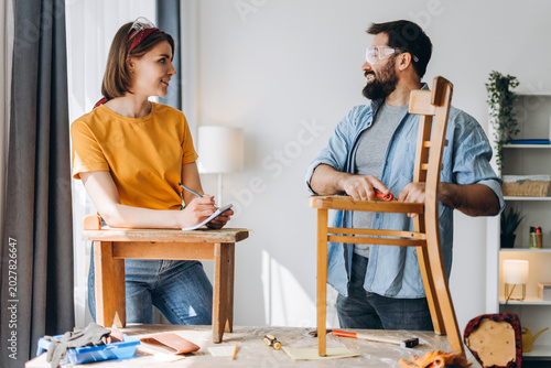Photos Smiling couple enjoying furniture restoration hobby and teamwork