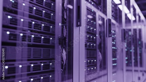 Purple tone data storage infrastructure room with glass cabinet reflections, illuminated rack servers, soft bokeh lights, and sleek secure cloud computing hardware corridor interior scene view