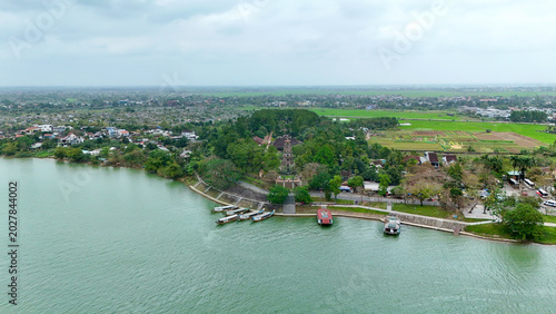 Fotografie Thien Mu Pagoda and Perfume River, Hue, Vietnam – 4K Aerial Drone view of Historic Buddhist Temple, Riverside Landscape, Boats and Scenic Countryside