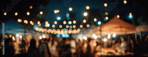Blurred outdoor summer night market with lights and tents  