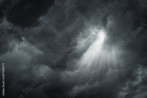Rays of light through the dark, ominous, stormy clouds.