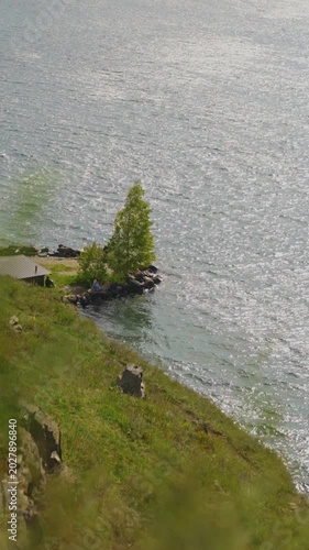 View of the sea and the coastline. Half of the frame is the sea, half is the shore. Vertical shot.