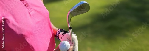 Fotografi Golf player prepares to swing with club and ball on sunny day on the green