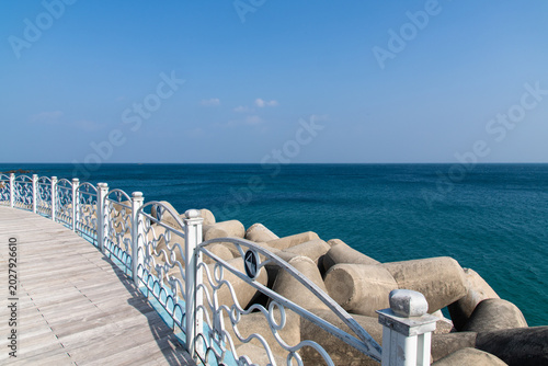 Waterfront promenade with decorative white railing and tetrapods