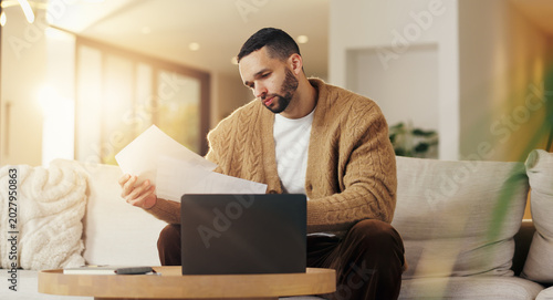 Fotografie Reading, paperwork and man with laptop in lounge, financial planning and checking home loan payment