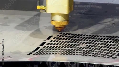 Laser cutting machine carving patterns on metal sheet with bright sparks