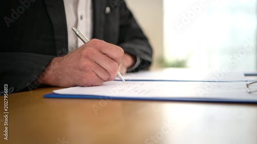 Close-up of businessman write documents at office desk with pen, professional corporate paperwork and business agreement concept