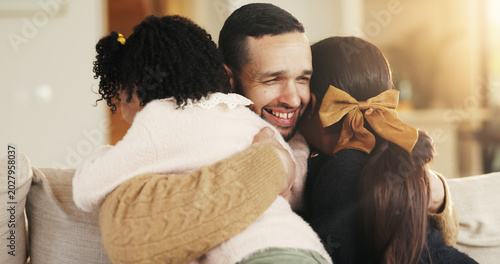 Dad, children and smile on sofa with hug, bonding together or support for family connection on weekend. Happy, man and young girl kids in home with embrace, parent care and love for fathers day.