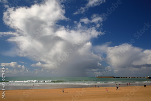 The beach in Les Sables d'Olonne, Vendee, France, viewed from the esplanade with a dramatic sky and clouds