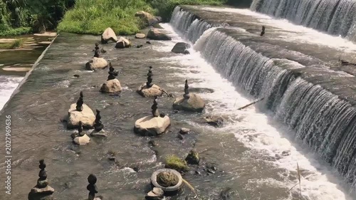 A scenic view of a multi-tiered concrete check dam transforming a river into beautiful cascading waterfalls