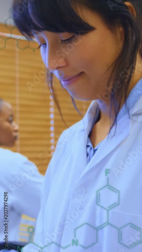 Vertical video: Lab tech tapping tablet, checking results, molecules appearing from gloves to face