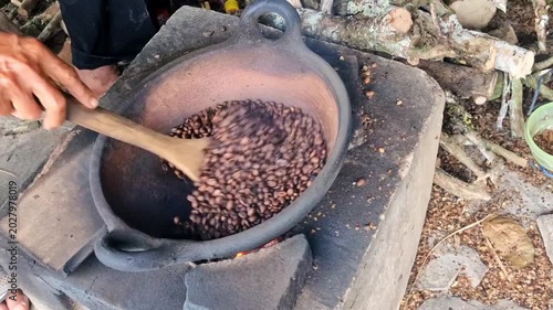 Roasted coffe bean by hand in a traditional clay pan