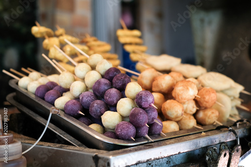Grilled sweet potatoes and purple sweet potatoes on skewers for street food or takeout.