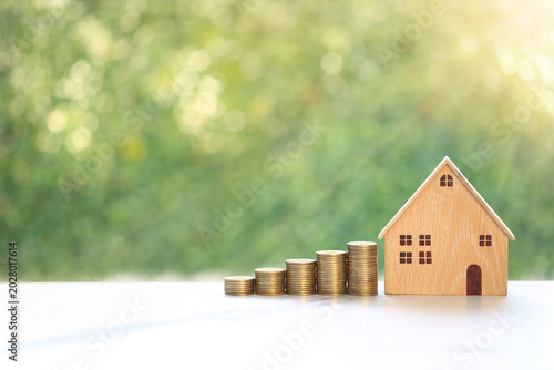 Mortgage,Model house and stack of coins money on natural green background,Business investment and real estate concept